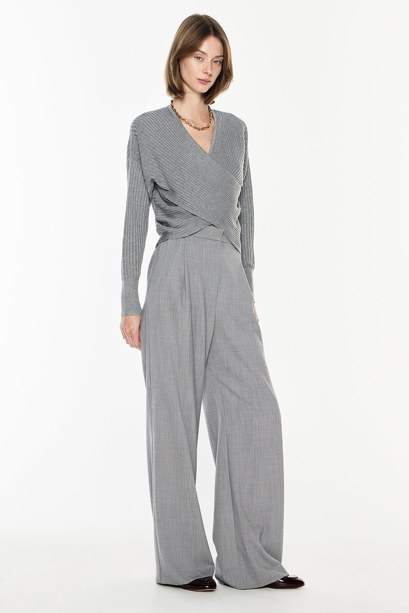 Woman wearing a gray jumpsuit on a white background