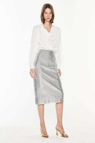 Woman wearing a white blouse and patterned skirt on a white background